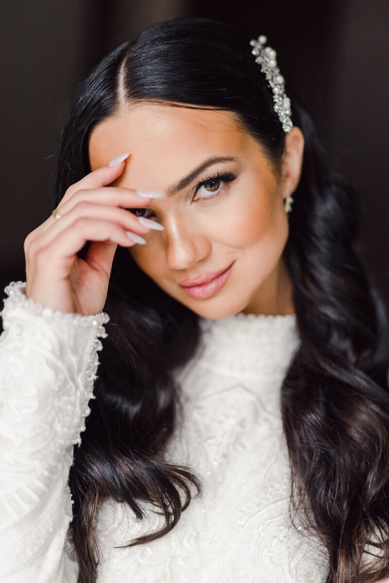 Close bridal portrait with dark waves and a pearl hair accessory